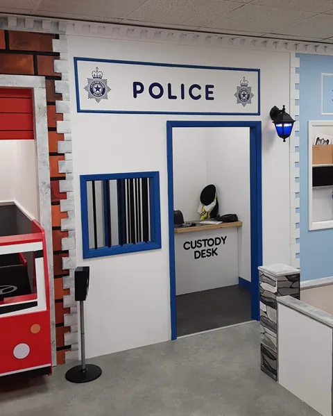 The blue and white Police Station with its little custody room